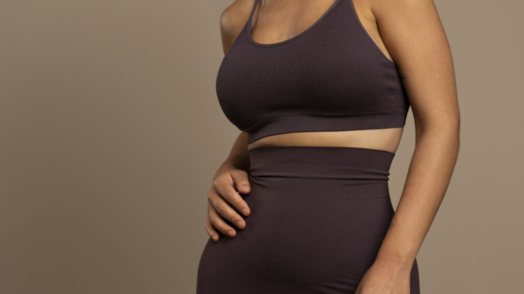 Close-up of woman’s torso wearing dark brown ribbed shapewear top and bottoms.