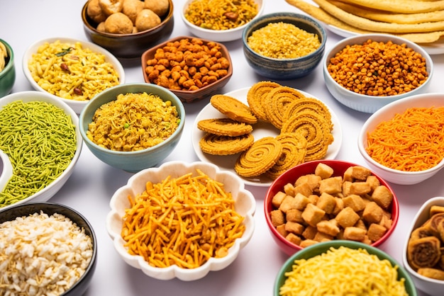 Indian tea-time snacks like sev, chivda, farsan and bakarwadi in assorted bowls.